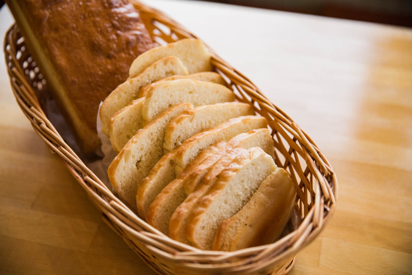 A loaf of salt rising bread sliced in a wicker basket
